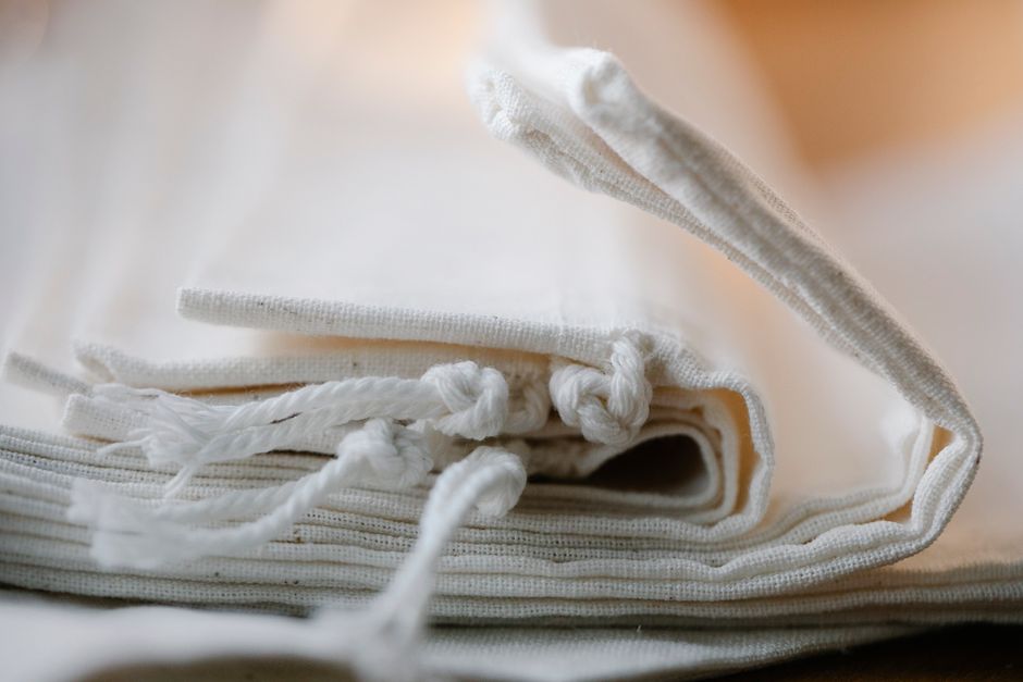 Sac en tissu blanc plié, idéal pour des courses zéro déchet et réduire l'utilisation de plastique.