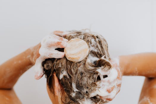 Femme lavant ses cheveux avec un shampoing solide, mousse sur ses mains et cheveux. Contexte écolo et soins naturels.