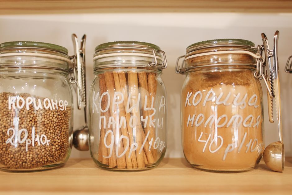 Bocaux en verre contenant des épices et des biscuits, étiquetés pour une organisation optimale en cuisine.