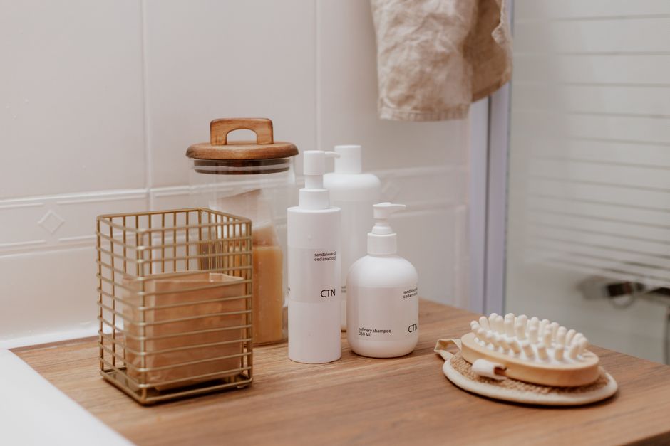 Produits de nettoyage et accessoires sur un plan de travail en bois, ambiance minimaliste et naturelle.